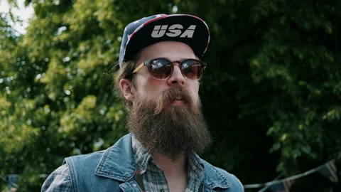 Man with USA hat looking into the distance, shaking his head and shrugging Stock Footage 133605609