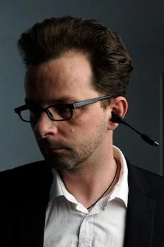 A man with a USB cable in his ear Stock Photos