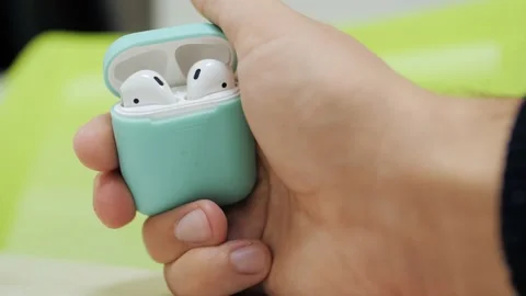 Man use Apple Earpods 2 opening the charging case and taking right earphone Video stock 169783774