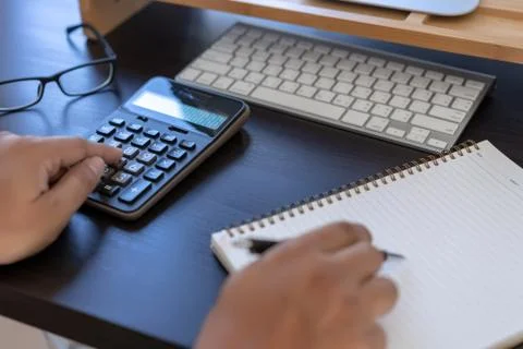 Man use calculator  make note with calculate about cost  in office Close up Stock-Fotos