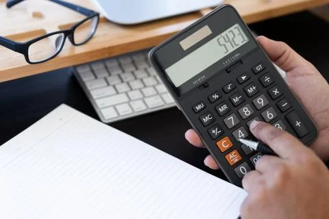 Man use calculator  make note with calculate about cost  in office Close up Stock Photos