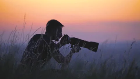 The man use the camera in the middle of beautiful field on holographic backgroun 動画素材 133722593