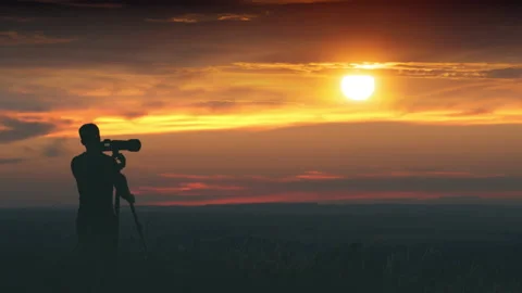 The man use the camera with tripod against the beautiful sunset background Stock Footage 133721492