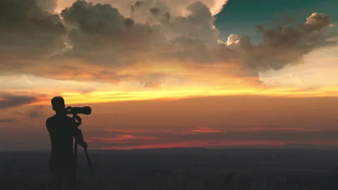 The man use the camera with tripod against the beautiful sky background 動画素材 133721500