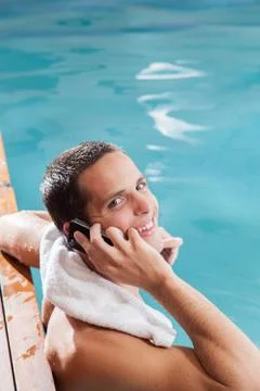Man use the cellphone in the edge of the pool Foto stock