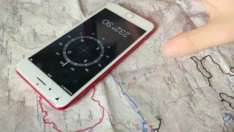 Man use digital iphone compass for trekking. digital compass and old map. Stock-Footage 231698156