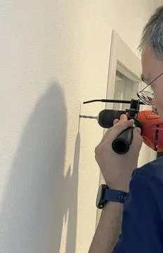 Man use drill with limiter to make hole in wall. Tools and hobbies. Home Stock Photos