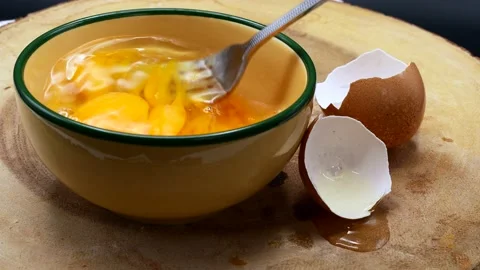 Man Use Fork To Beats The Eggs In Yellow Bowl On wooden Board. Vídeo Stock 194631860