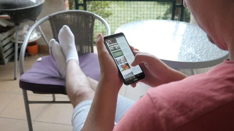 A Man use Mobile Smart Phone, browse Videos on Youtube Channel Stock Footage 91094447