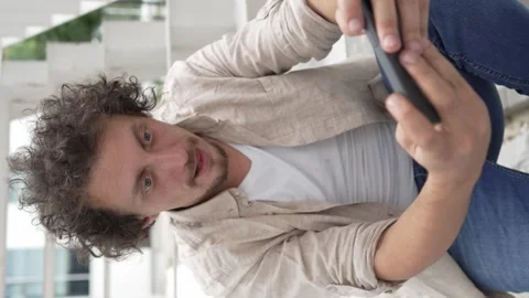 Man use mobile smart phone play video games sit outdoor Stock Footage 248306097