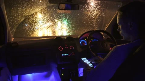 The Man Use The Phone In A Car In The Rainy City Inside