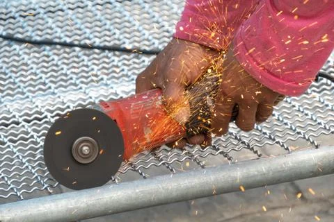 Man used angle grinder without cover guard cutting metal net to make bird cag Stock Photos