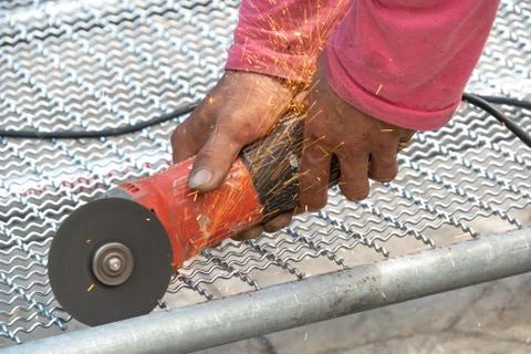 Man used angle grinder without cover guard cutting metal net to make bird cag Stock Photos