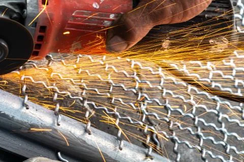Man used angle grinder without cover guard cutting metal net to make bird cag Stock Photos