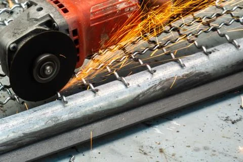 Man used angle grinder without cover guard cutting metal net to make bird cag Foto stock