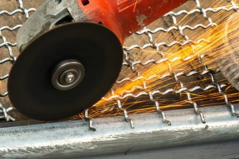 Man used angle grinder without cover guard cutting metal net to make bird cag Foto stock