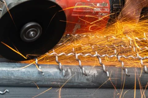 Man used angle grinder without cover guard cutting metal net to make bird cag Stock Photos