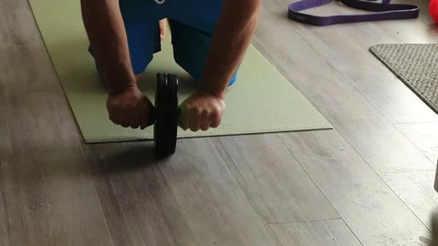 Man uses ab roller in living room due to covid 스톡 동영상 146294593
