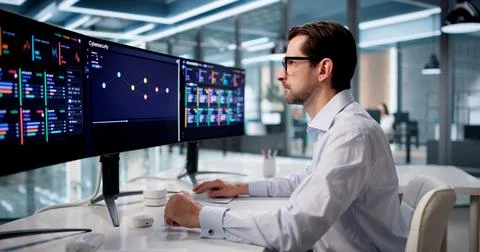 Man Uses Advanced Software Tools To Monitor Cybersecurity Threats Daily. Stock Photos
