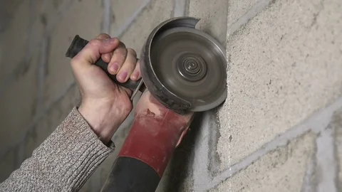 The Man Uses the Angular Grinder for Cutting of a Wall Video stock 74794932
