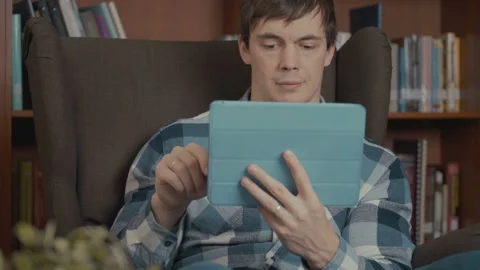 Man uses the app on his computer tablet 스톡 동영상 96718160