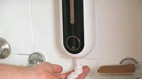 Man uses Automatic Foaming Wall Mounted Motion Sensor Touchless Liquid Soap Stock Footage 245657107