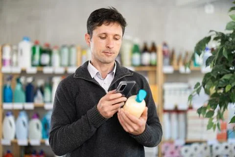 Man uses barcode to get information about liquid hand soap in mobile application Stock Photos
