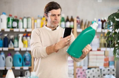 Man uses barcode to get information about liquid detergent in mobile application Stock-Fotos