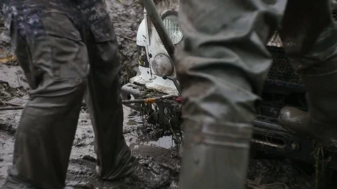 Man uses big hoisting jack to lift off-road vehicle in slow motion. Try to get Stock Footage 77429901