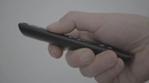 Man uses black remote control of a smart tv. Closeup cinematic 4k shot Stock Footage 263482034