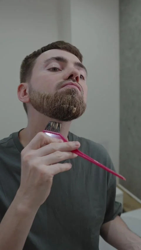 Man uses brush and mirror for neat beard finish at home Vídeo Stock 333332540