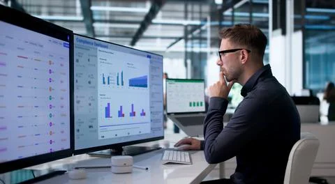 Man Uses Computer Dashboard To Track Real-time Business Risk Data. Stock Photos