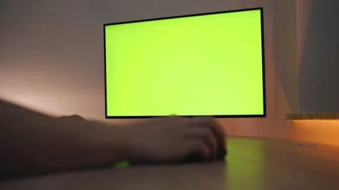 Man Uses computer with Green Mock-up Screen While Sitting at the Desk Stock Footage 147292972