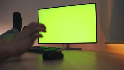 Man Uses computer with Green Mock-up Screen While Sitting at the Desk Stock Footage
