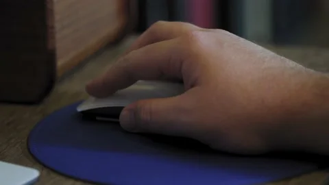 Man uses computer mouse with blue mouse pad close up. Work from home. Video stock 220430252