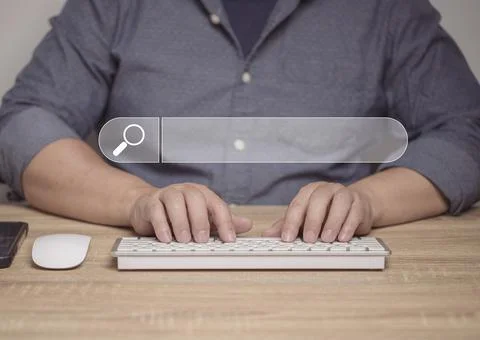 A man uses a computer to search for information through online search systems Stock Photos