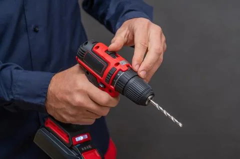 The man uses a cordless screwdriver. close-up Fotos de archivo