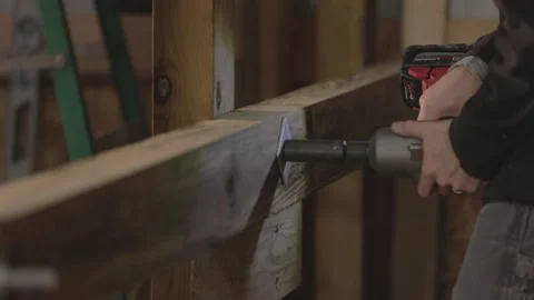 A man uses a drill to make a hole in wood in slow motion. Stock Footage 147981080