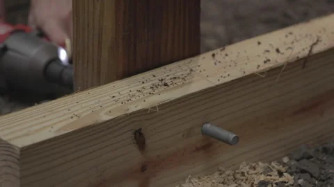 A man uses a drill to make a hole in wood. Stock Footage 147982086