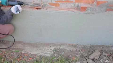 A man uses a drill to remove a brick from a foundation. Chipping bricks from a Stock-Footage 250937791