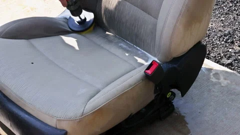 Man uses drill to work on car seat at garage Stock Footage 342731301