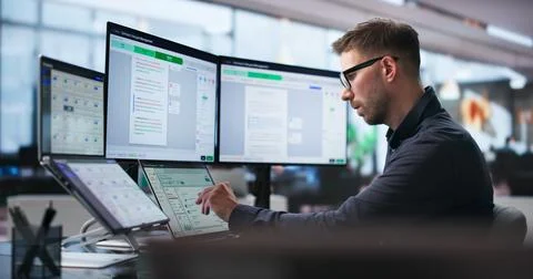 Man Uses Dual Touchscreen Laptop To Review Contract Agreements Efficiently. Stock Photos
