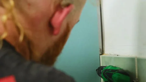 Man uses electric drill making hole in plasterboard wall Video stock 304407761