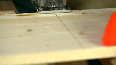 A man uses an electric saw to cut wooden planks. Stock Footage 128872015