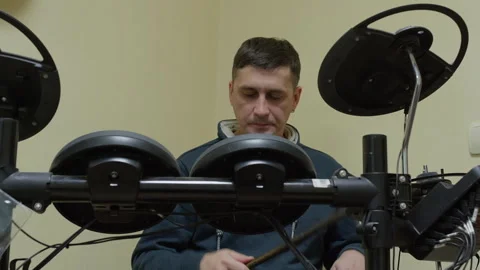 Man uses electronic drum pad machine with focused expression during music Stock Footage 322095478