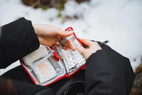 A man uses a first aid kit in the forest, a set of pills in a package. Foto stock