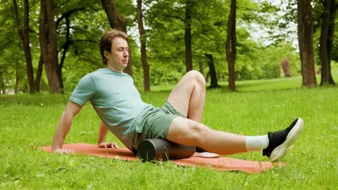 Man uses a foam roller for self massage and muscle recovery on his leg. This out Stockbeeldmateriaal 340653918