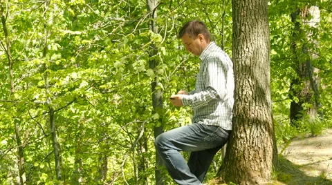 A man uses his iPad outside in the park Stock Footage 63147858