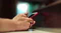 Man uses his smartphone. Man hold in hands red mobile phone HD Footage