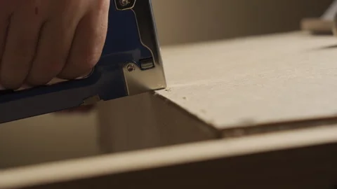 A man uses an industrial stapler to connect wooden parts  Stock Footage 282201222